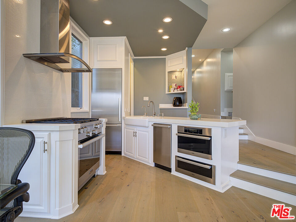 7800 Veragua Drive, Unit 1 Playa del Rey, CA 90293 - Photo 17 of 42 a kitchen with stainless steel appliances kitchen island granite countertop a stove a sink and a refrigerator