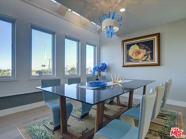 a view of a dining room with furniture a chandelier and wooden floor
