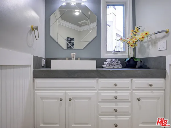 a bathroom with cabinets and mirror