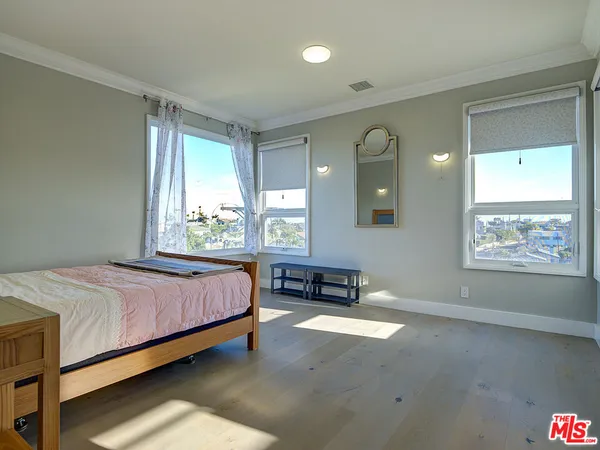a bed sitting in a spacious bedroom next to a window