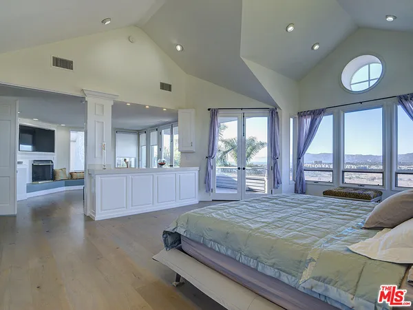 a spacious bedroom with a large bed and a large window