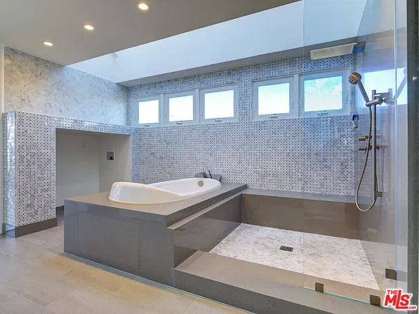 a bathroom with a tub a sink and mirror