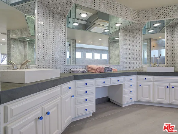 a bathroom with a granite countertop double vanity sink and mirror