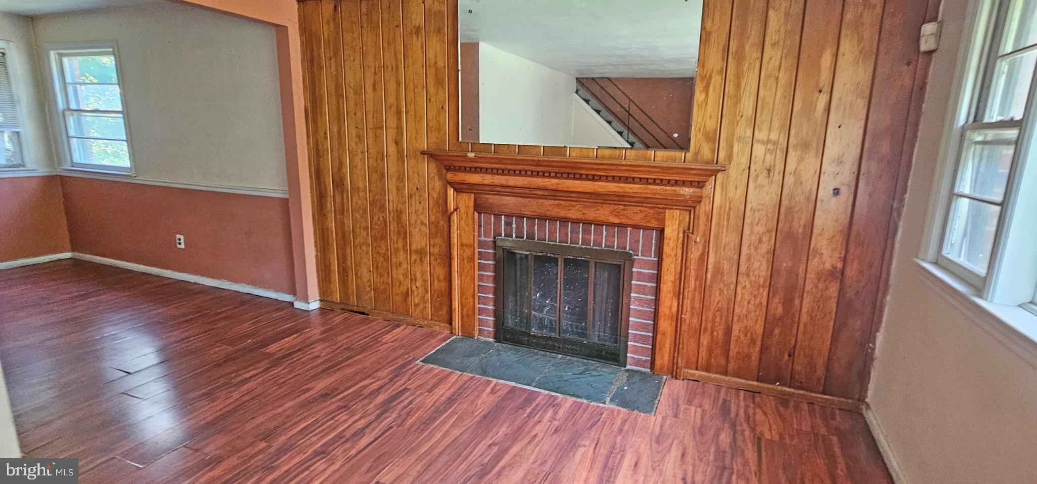 8517 Oglethorpe Street Hyattsville, MD 20784 - Photo 2 of 15 an empty room with wooden floor fireplace and windows