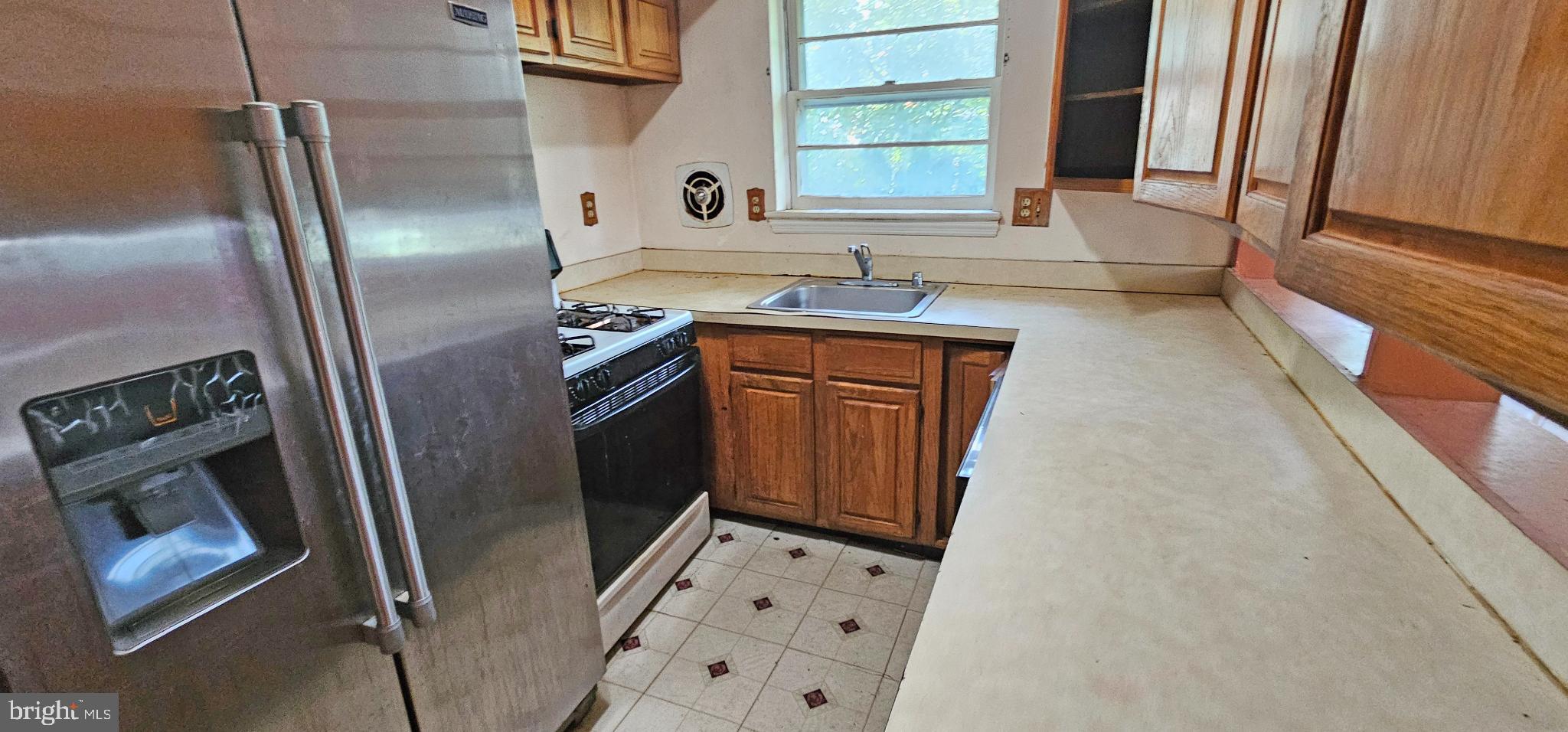 8517 Oglethorpe Street Hyattsville, MD 20784 - Photo 4 of 15 a kitchen with stainless steel appliances a refrigerator sink and wooden floor