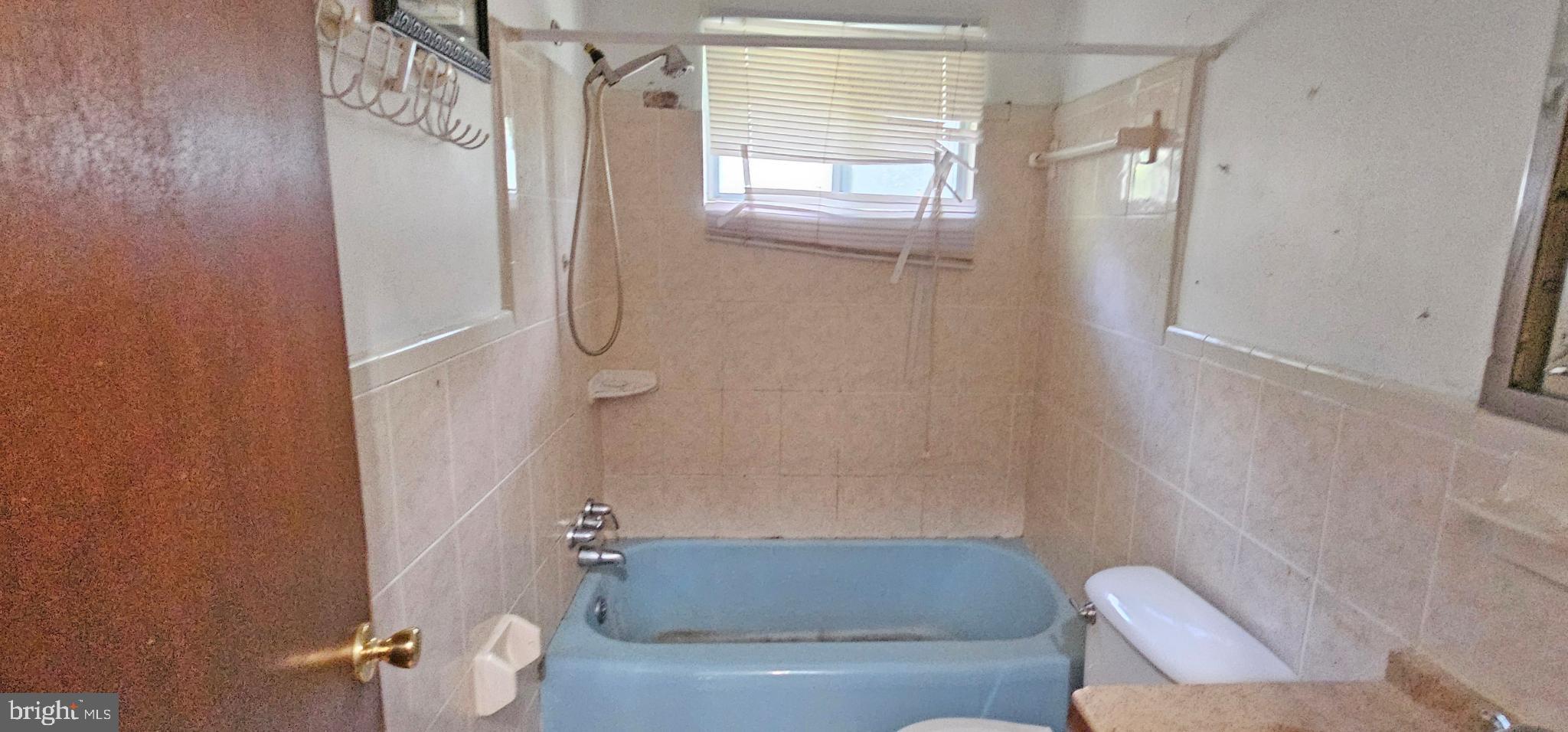 8517 Oglethorpe Street Hyattsville, MD 20784 - Photo 6 of 15 a bathroom with a granite countertop bathtub shower and toilet