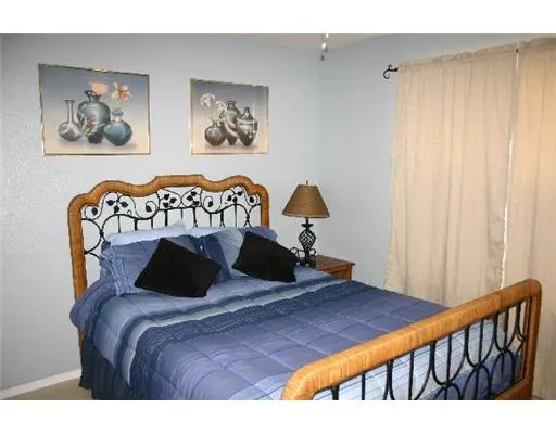 a bedroom with a bed and paintings on the wall