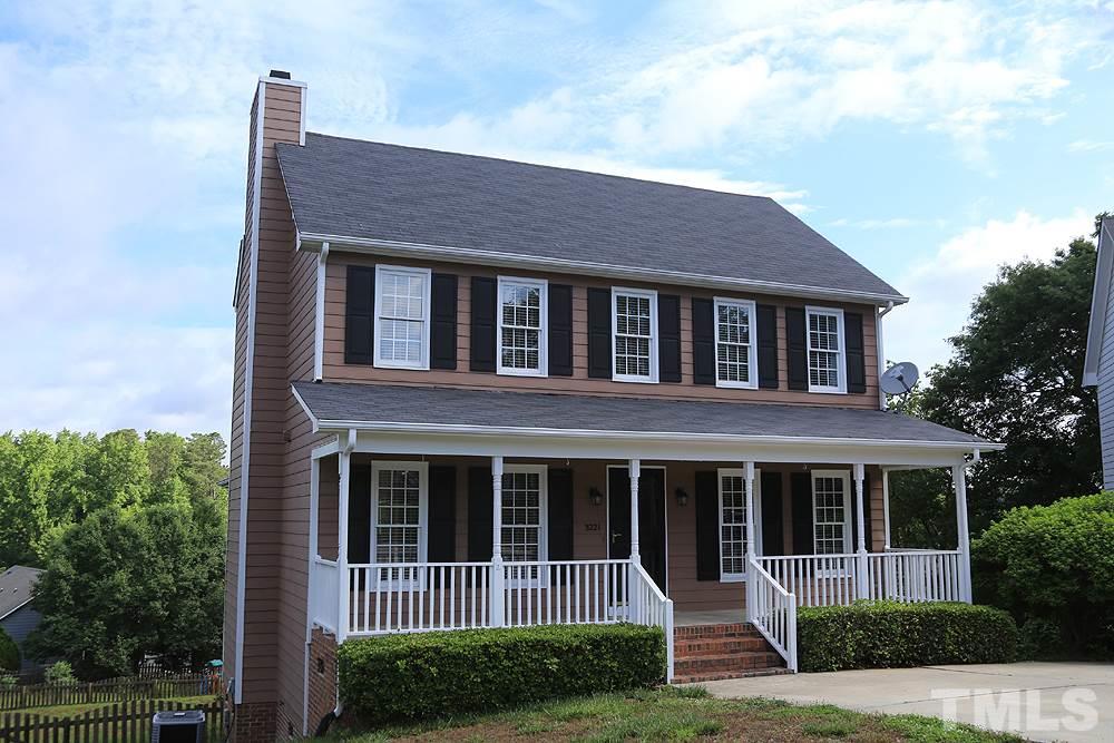 a view of brick house with a small yard and plants