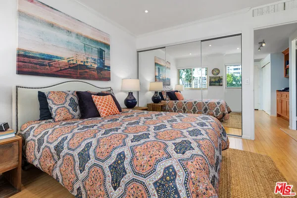 a bedroom with a large bed and a chandelier