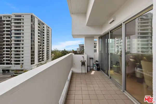 a view of balcony with a couple of cars parked in front of main door