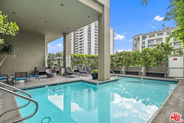 a view of a swimming pool with chairs in patio