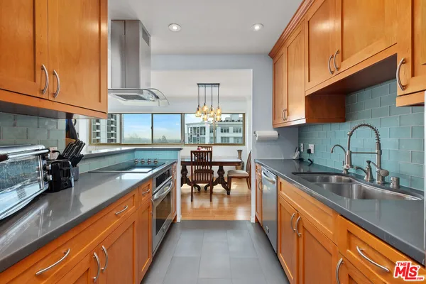 a kitchen with stainless steel appliances granite countertop sink stove top oven and cabinets