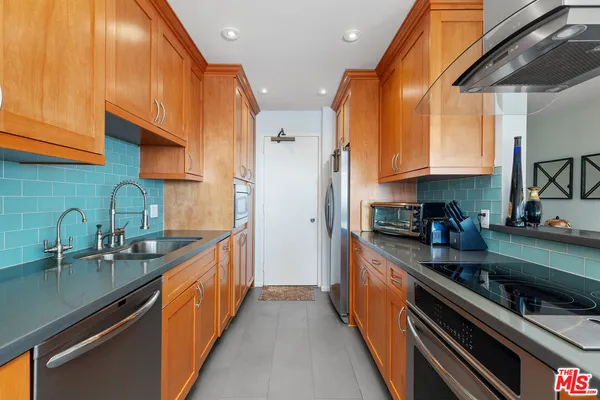 a kitchen with stainless steel appliances a sink a stove and a refrigerator