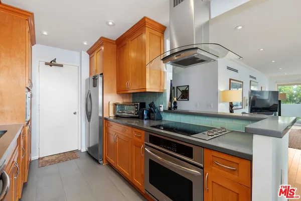 a kitchen with stainless steel appliances granite countertop a stove a sink and a refrigerator