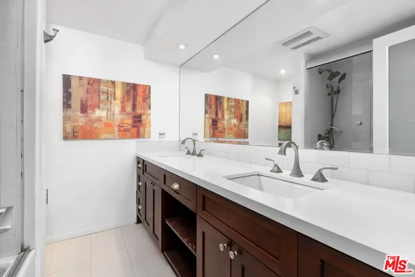 a bathroom with a double vanity sink and a mirror