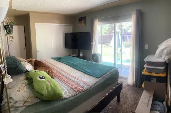 a bedroom with a bed and large windows