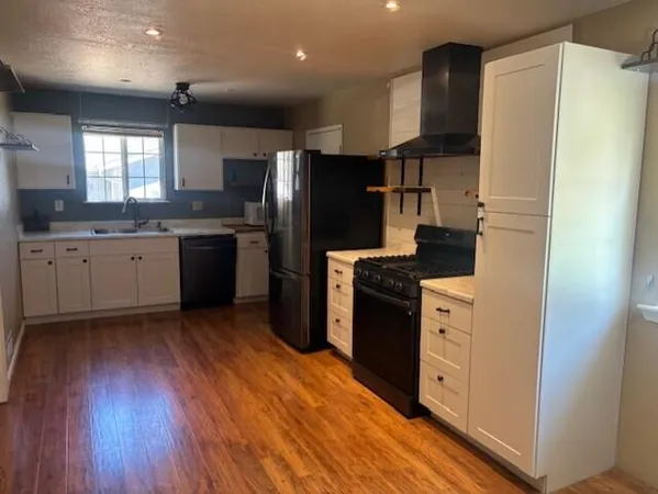 a kitchen with granite countertop a refrigerator stove and sink