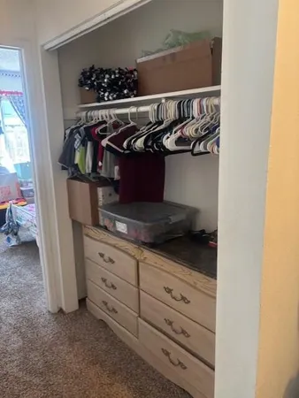 a view of walk in closet with clothes and shoes