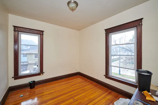 a view of a room with wooden floor and windows
