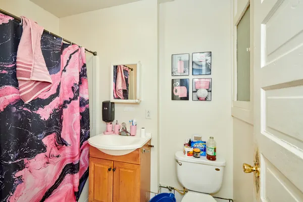 a bathroom with a sink a toilet and a shower curtain