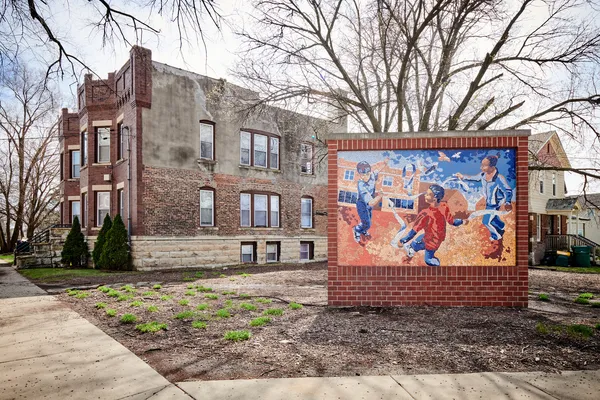 a view of a brick building with a large tree