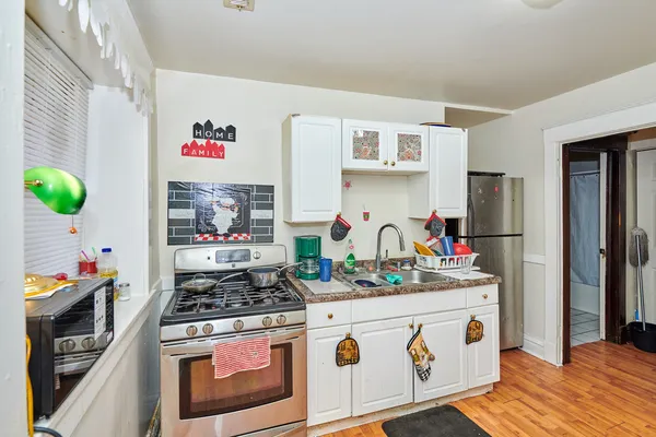 a kitchen with stainless steel appliances granite countertop a stove and white cabinets