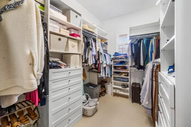 a view of walk in closet with clothes and shoes