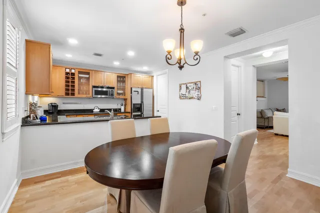 a view of a dining room and livingroom with furniture wooden floor a chandelier