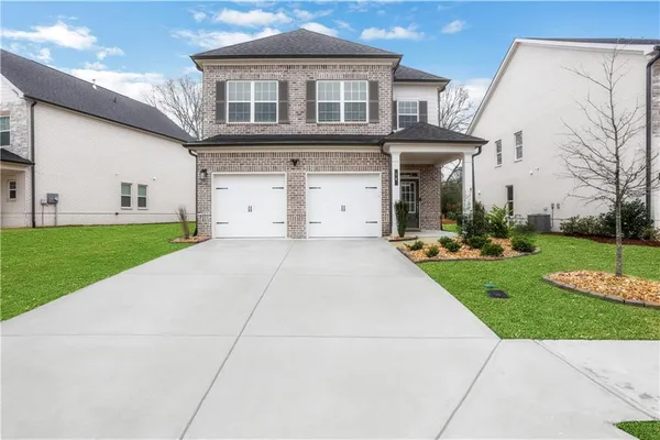 a front view of a house with a yard and trees