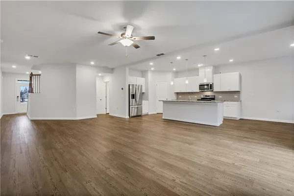 a view of kitchen with refrigerator stove and cabinets