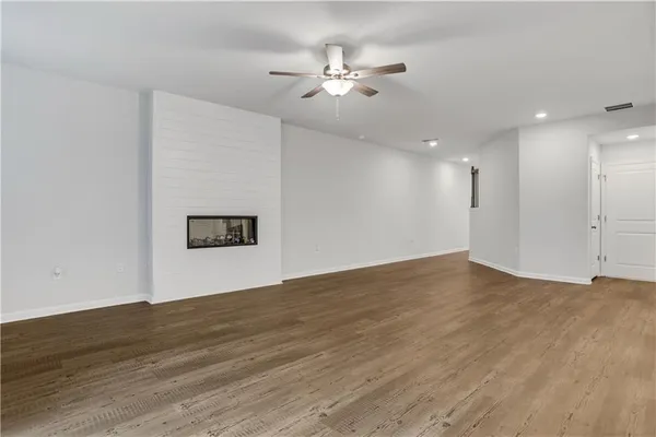 a view of a big room with wooden floor and a ceiling fan