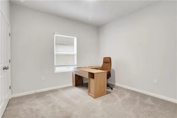 a view of a workspace with furniture and a window