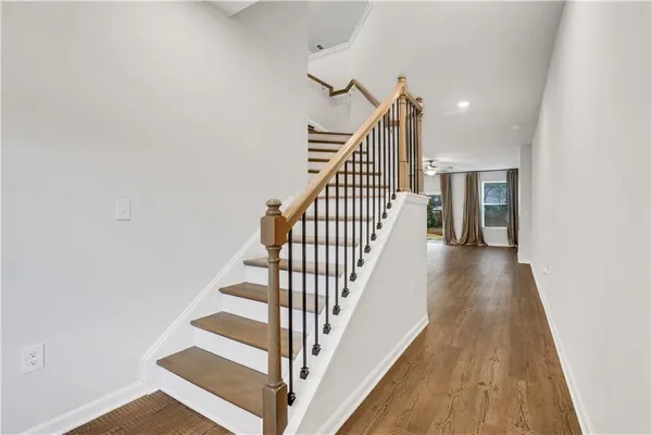 a view of staircase with wooden floor and white walls