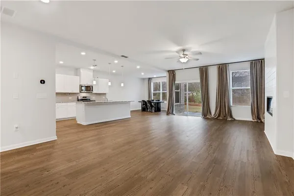 a view of kitchen with refrigerator stove and wooden floor