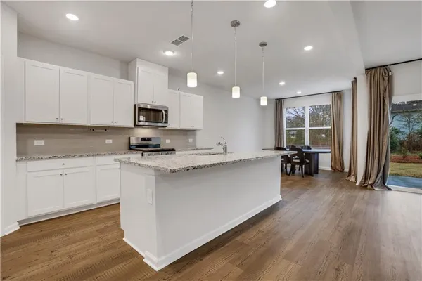 a kitchen with microwave a stove and cabinets