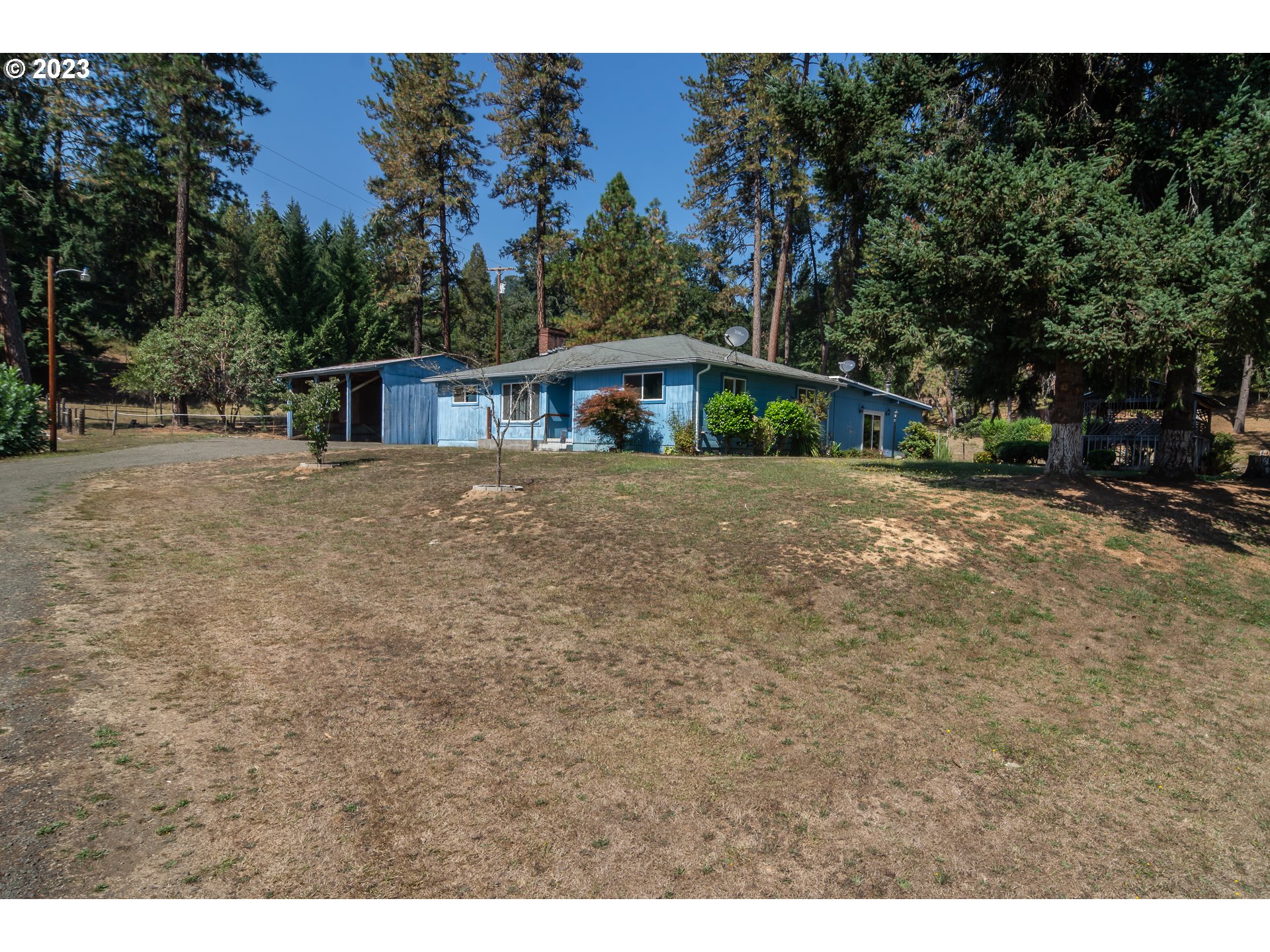 959 Doerner Road Roseburg, OR 97471 - Photo 5 of 40 a backyard of a house with plants and large trees