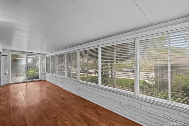 a view of empty room with wooden floor and windows