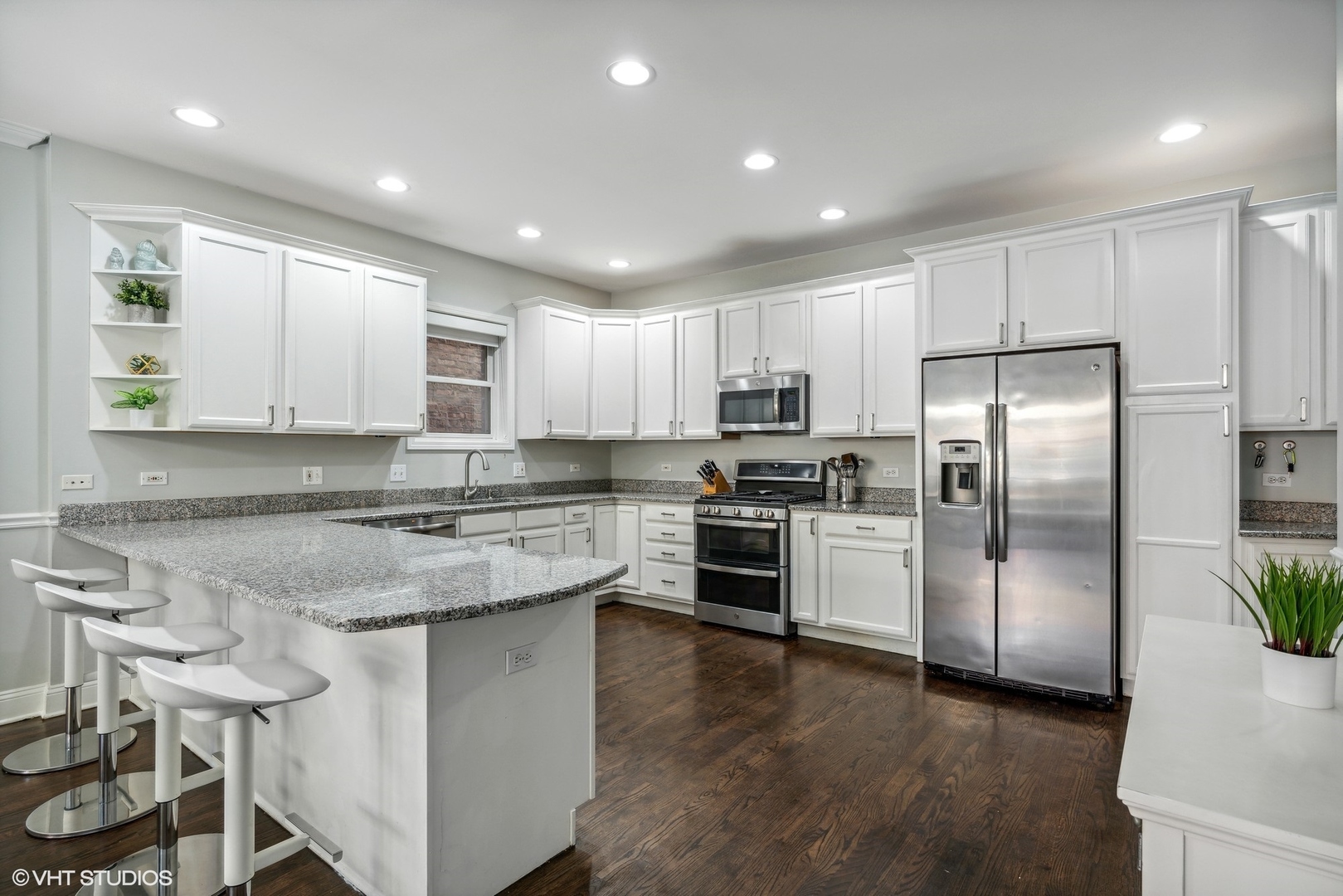 3818 North Clark Street, Unit 1S Chicago, IL 60613 - Photo 5 of 22 a kitchen with kitchen island a refrigerator and a stove top oven