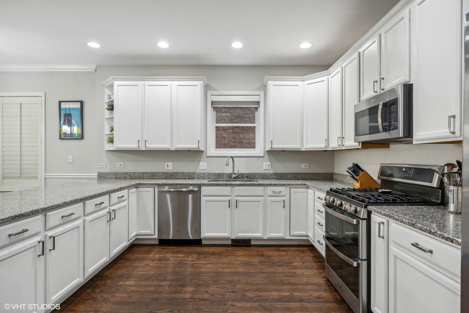 3818 North Clark Street, Unit 1S Chicago, IL 60613 - Photo 6 of 22 a kitchen with granite countertop cabinets stainless steel appliances a sink and dishwasher