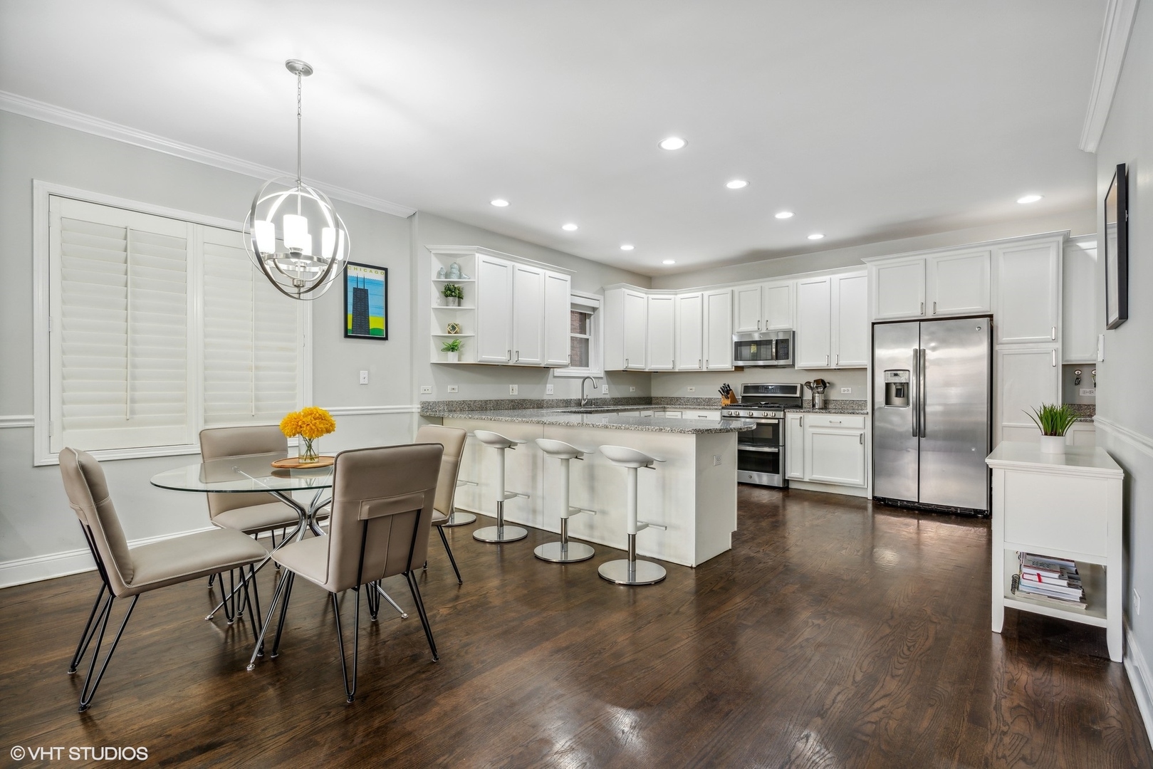 3818 North Clark Street, Unit 1S Chicago, IL 60613 - Photo 9 of 22 a kitchen with stainless steel appliances granite countertop a table chairs and a refrigerator