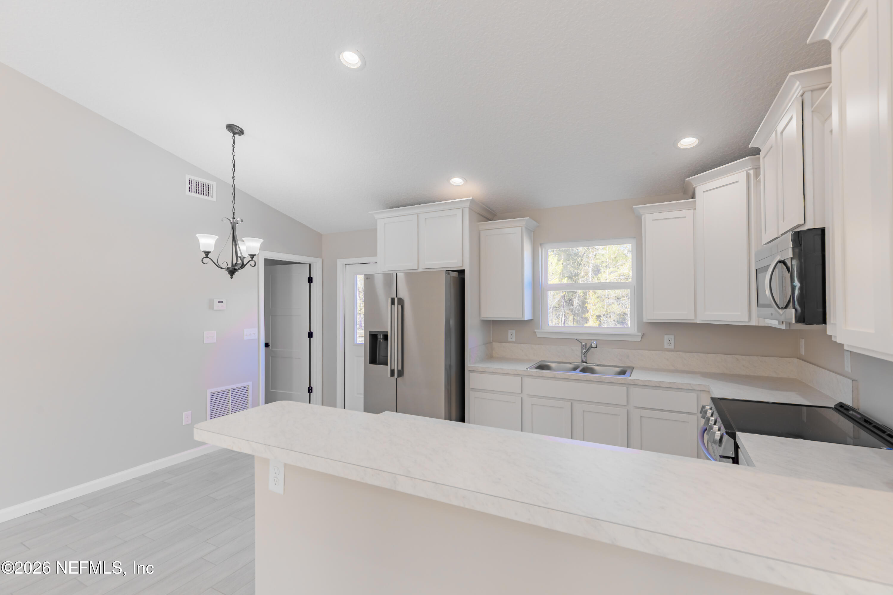 6202 Furman Avenue Keystone Heights, FL 32656 - Photo 13 of 24 a large white kitchen with a sink a refrigerator and a stove top oven