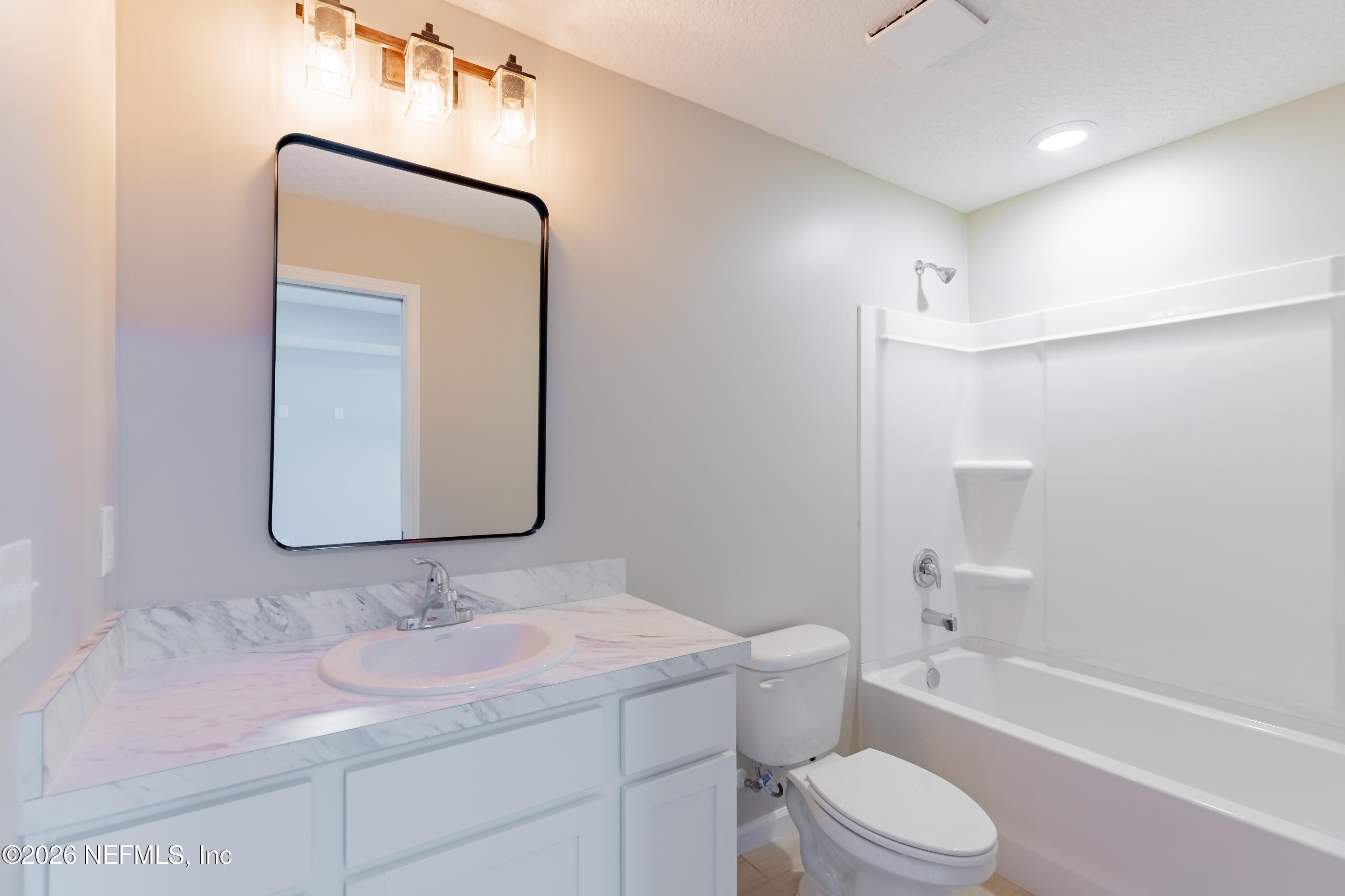 6202 Furman Avenue Keystone Heights, FL 32656 - Photo 18 of 24 a bathroom with a toilet a sink a tub and mirror
