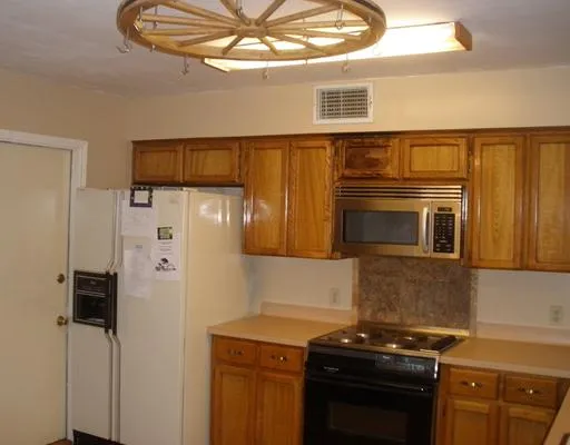 a kitchen with stainless steel appliances granite countertop a refrigerator and a stove top oven