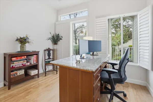 a view of a workspace with furniture and a window