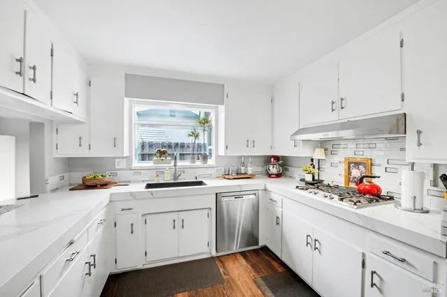 a kitchen with cabinets a sink dishwasher and white appliances with cabinets