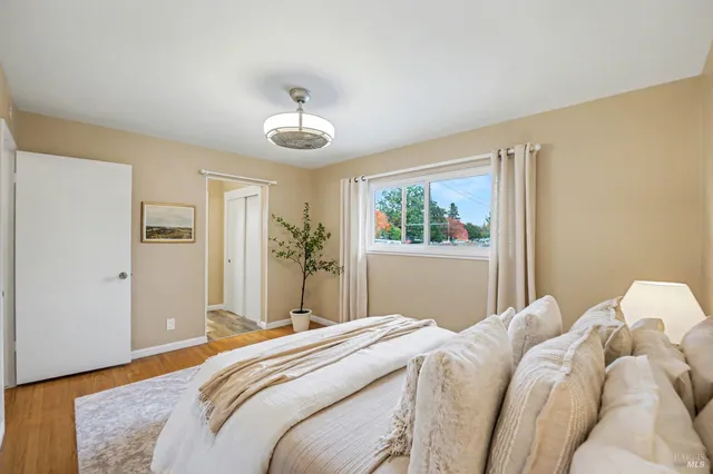 a bedroom with a large bed and wooden floor
