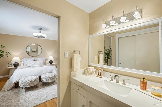 a bedroom with a bed and a mirror on the dresser