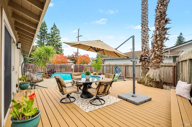 a view of a patio with table and chairs potted plants with wooden floor