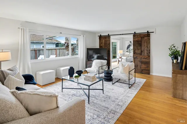 a living room with furniture and wooden floor