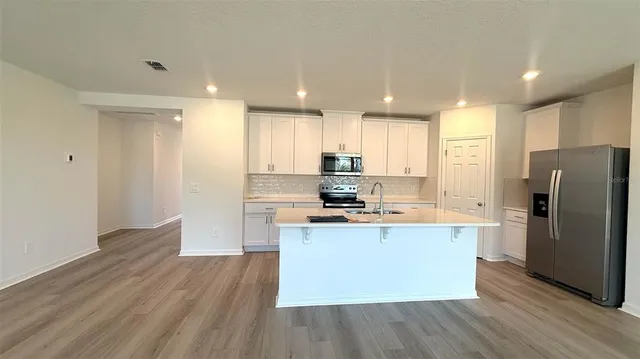 a kitchen with stainless steel appliances a refrigerator and a stove top oven